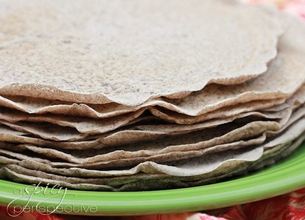 Cooked injera bread stacked on a plate. 
