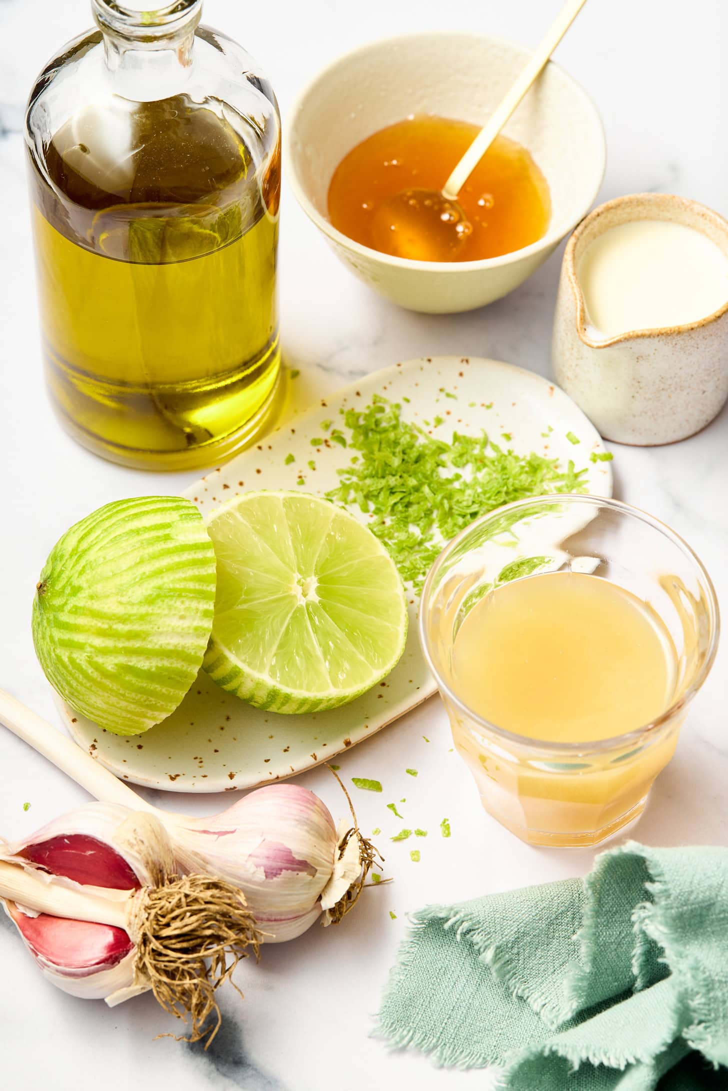 Zested limes, lime juice, honey, olive oil, and seasonings are prepared for a lime dressing recipe.