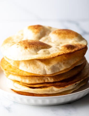 Fried Flour Tortillas stacked on white plate.