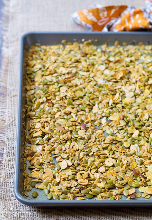 Homemade granola spread out on a baking sheet.