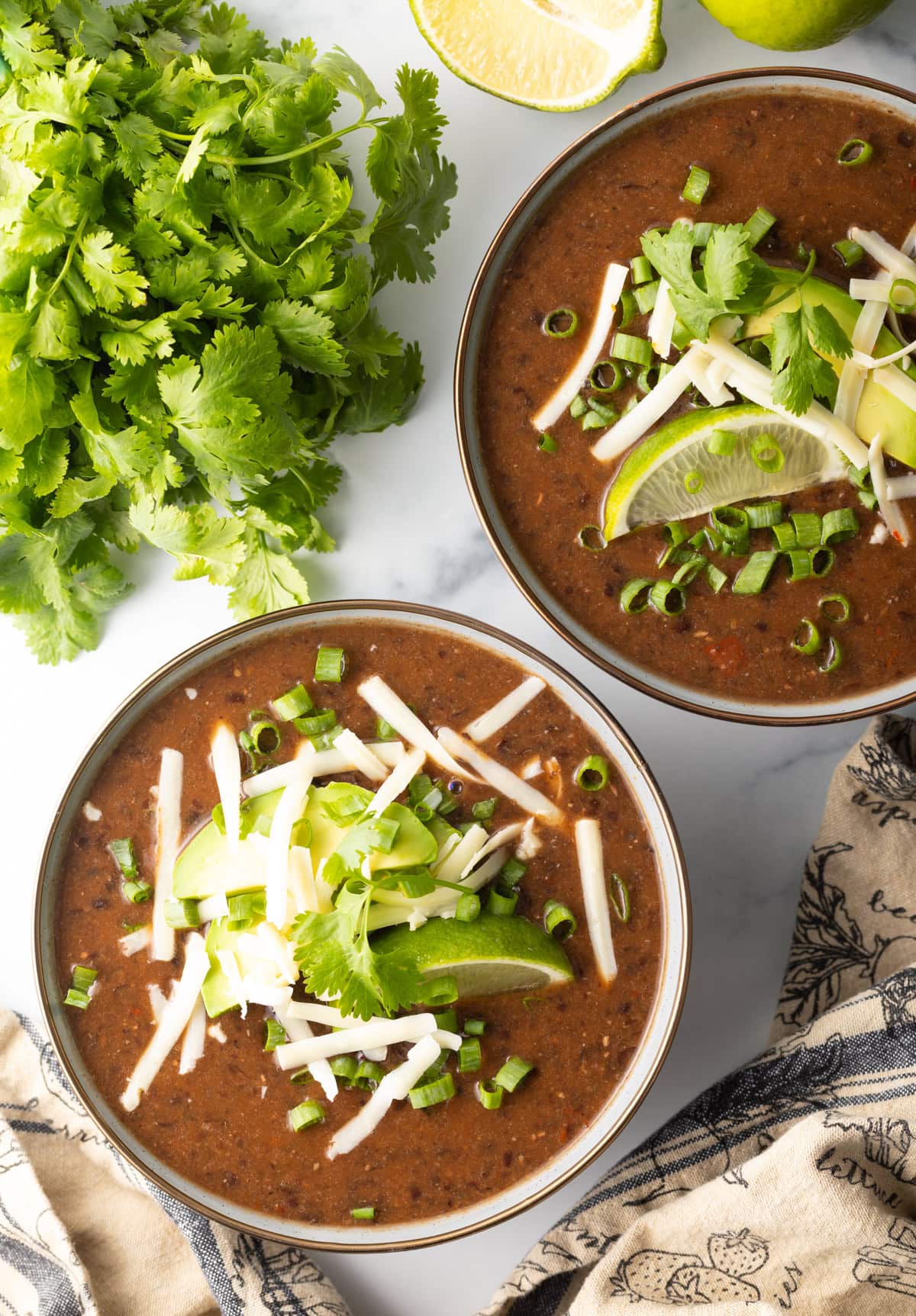 Top down view of two bowls filled with black bean soup. 