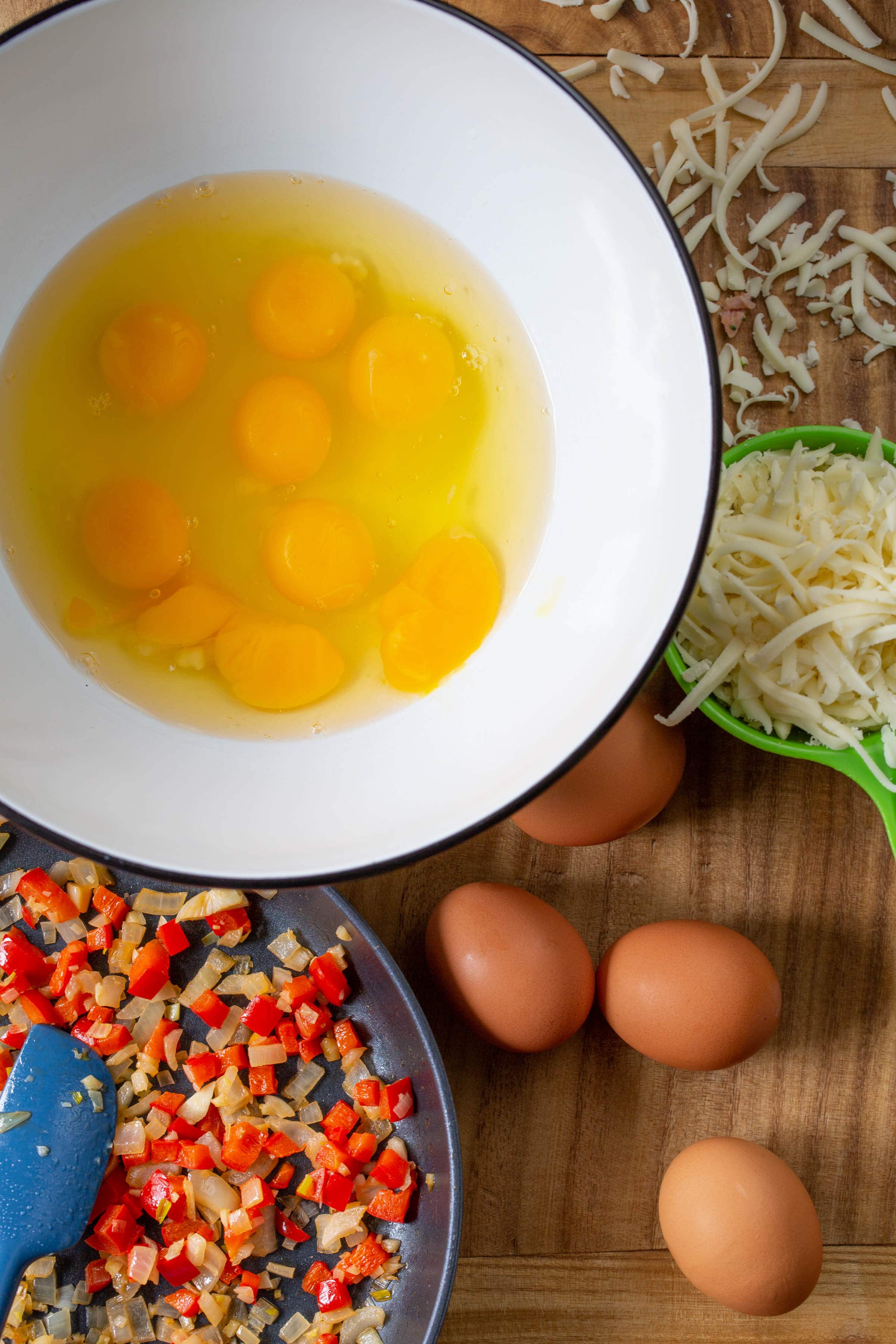 Top down shot of quiche ingredients on a wood surface.