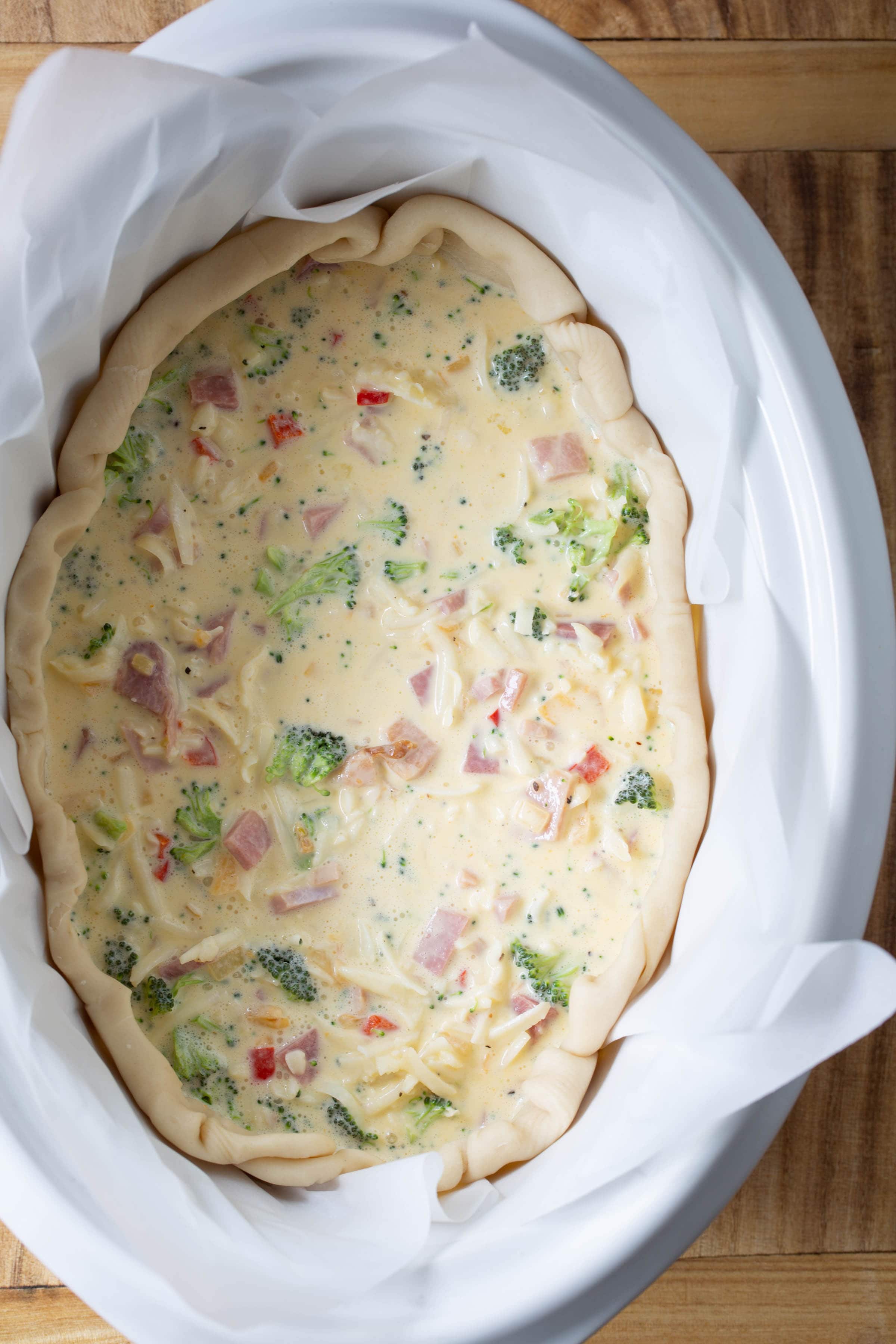 Top down view of uncooked egg mixture in the pie crust ready to cook in the crockpot.