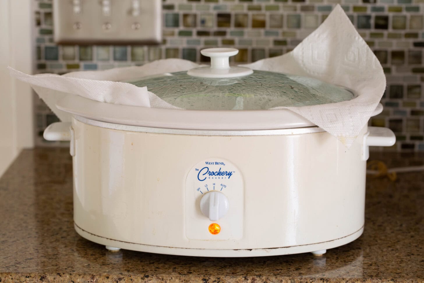 White crockpot on a kitchen counter.