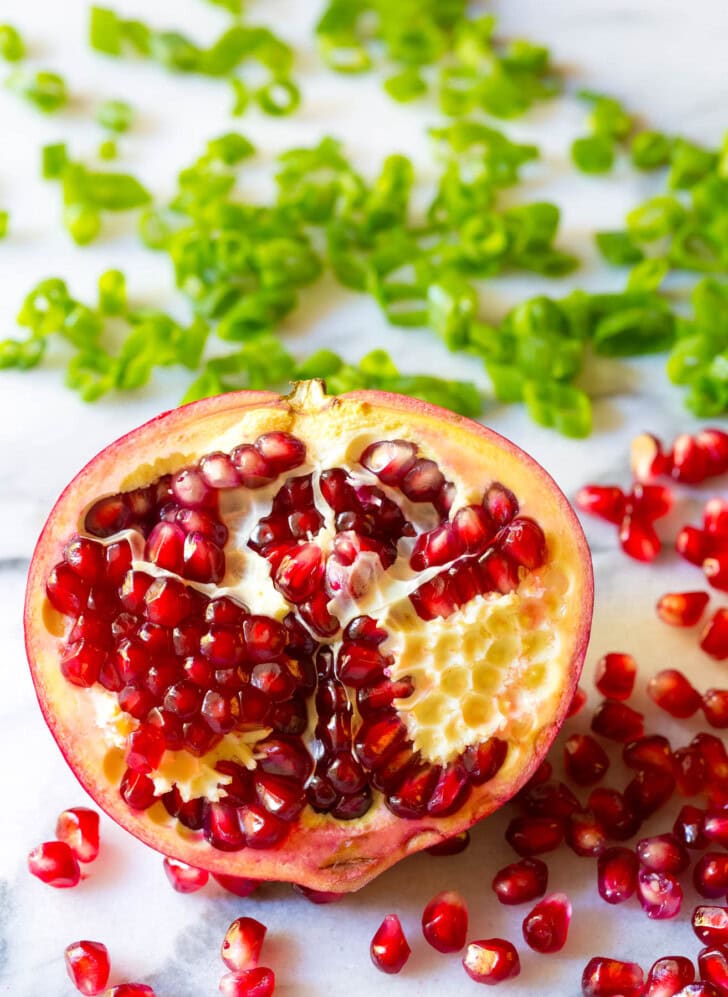Half of a pomegranate with the seeds popping out. 
