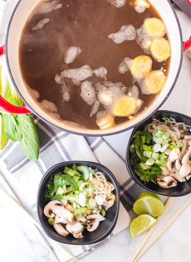 Chicken broth simmering with ginger, sauces and garlic.