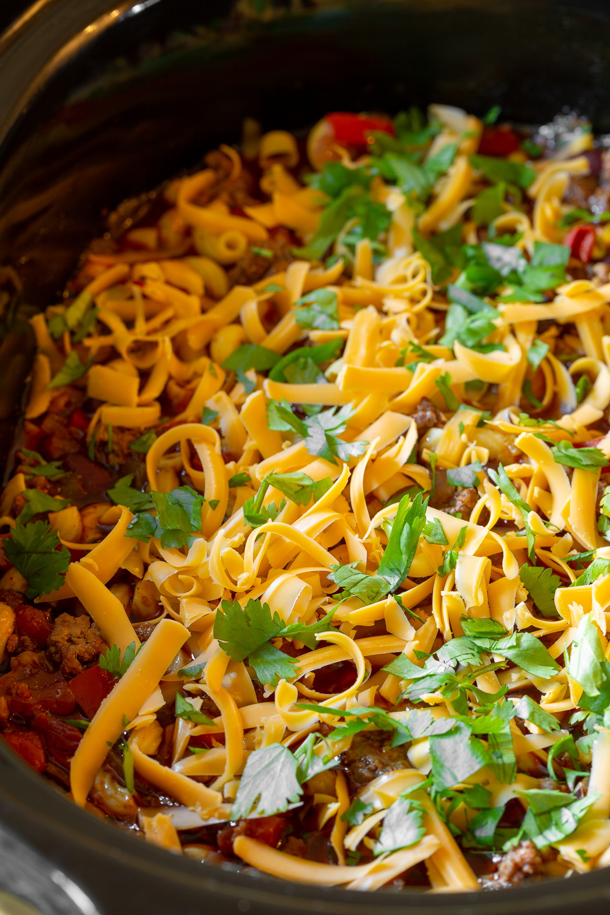 Plenty of shredded cheese and cilantro topping this chili mac
