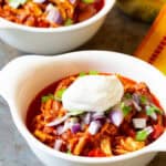 roasted red pepper chili in two white bowls with toppings