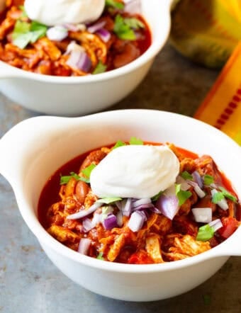 roasted red pepper chili in two white bowls with toppings