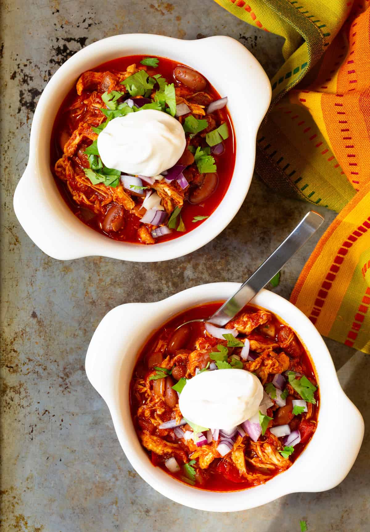 overhead shot of 2 bowls of chili with toppings