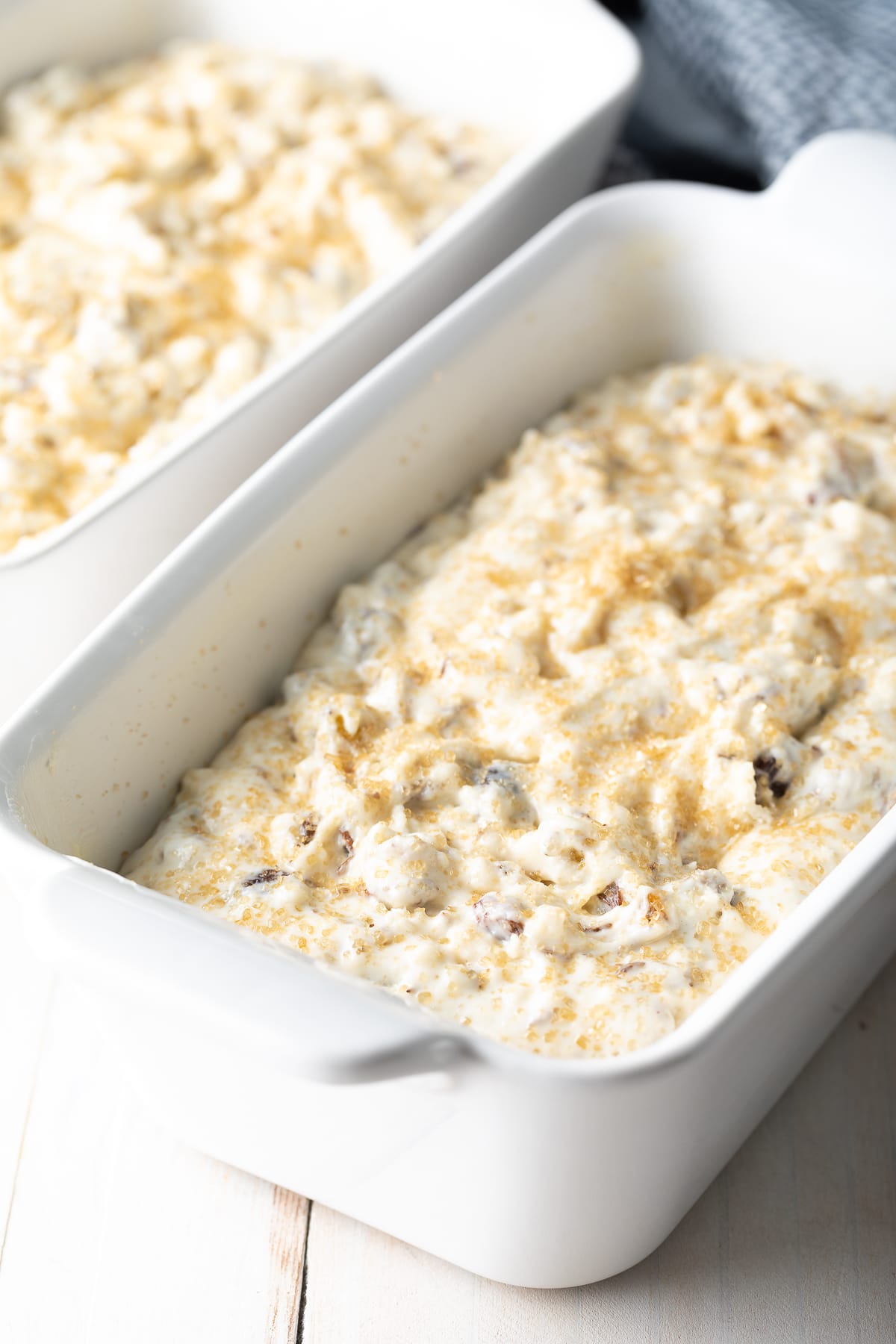 Bread batter poured into a loaf pan and topped with sugar. 