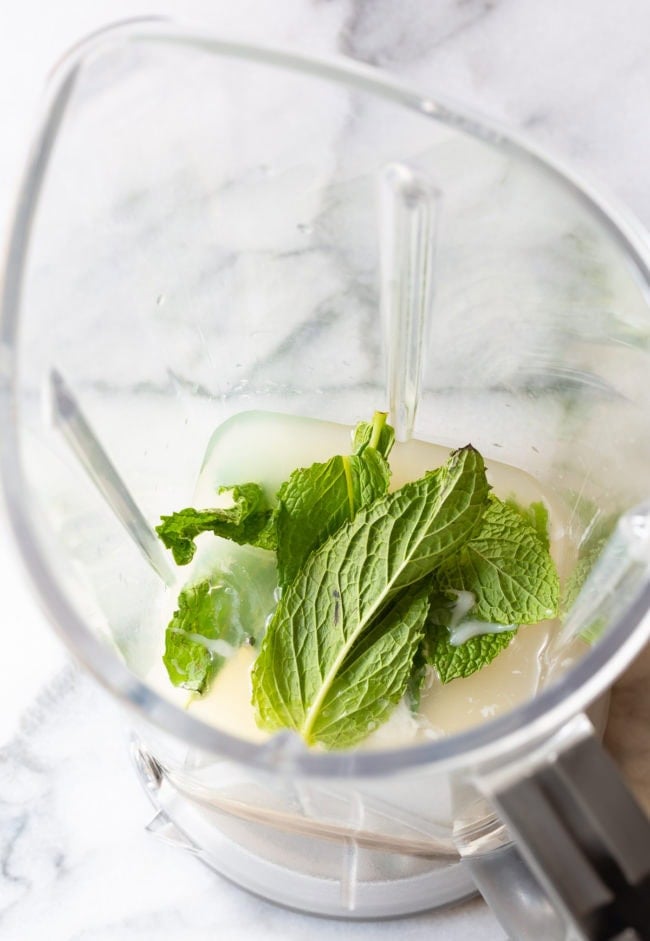 Ingredients measured into a jug including fresh mint leaves.