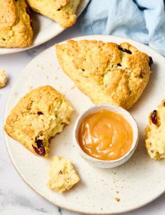 Walnut Cherry Scones on a plate with lemon curd - one broken open