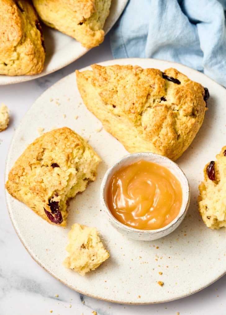 Walnut Cherry Scones on a plate with lemon curd - one broken open
