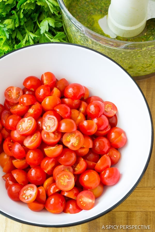 Top down view white bowl with halved cherry tomatoes.