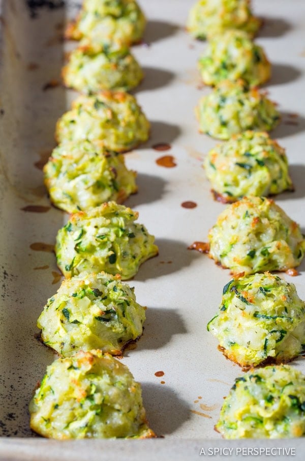 Zucchini tots in a baking sheet after being baked. 
