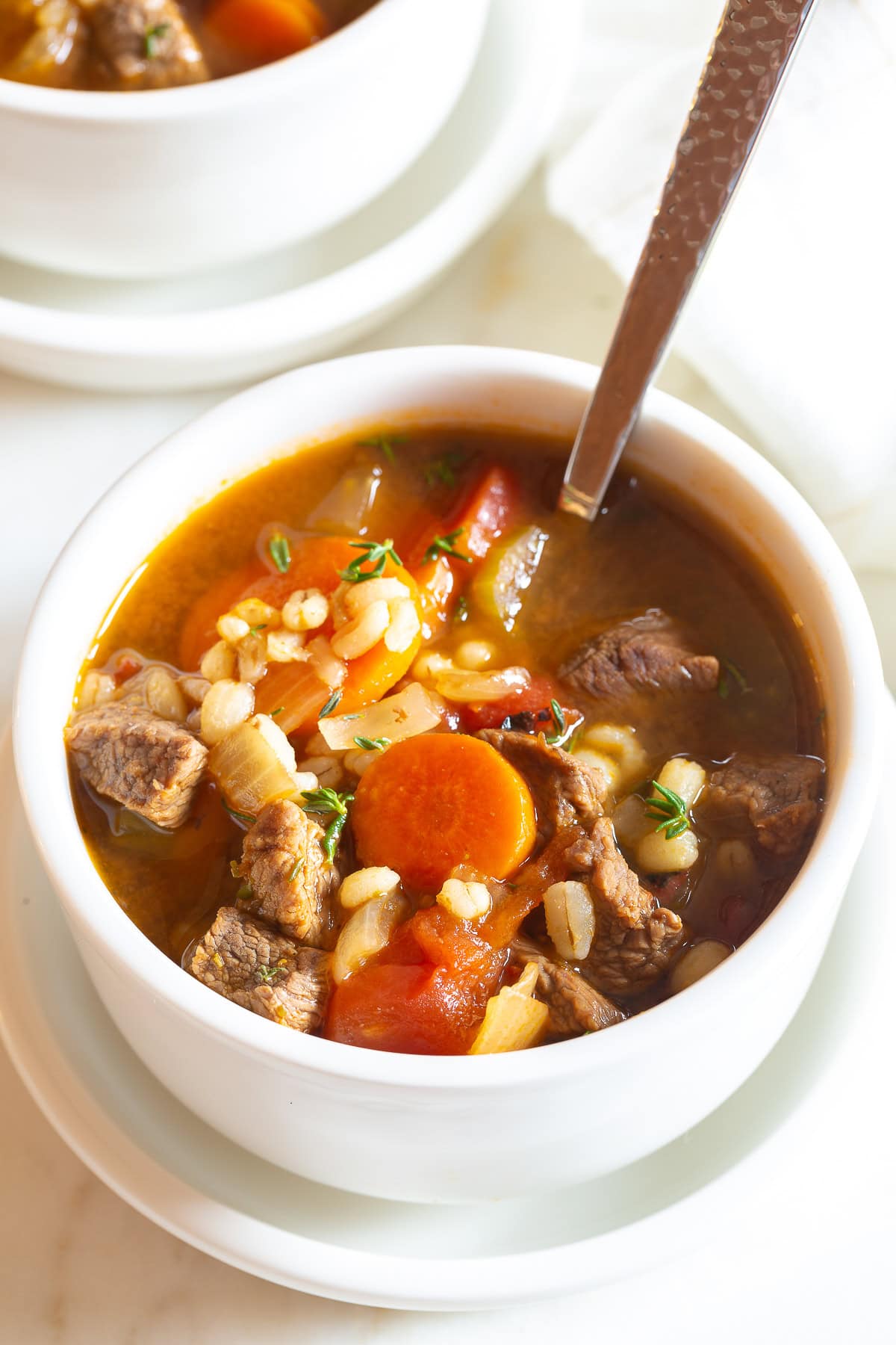 beef and barley soup close up in a bowl with vegetables