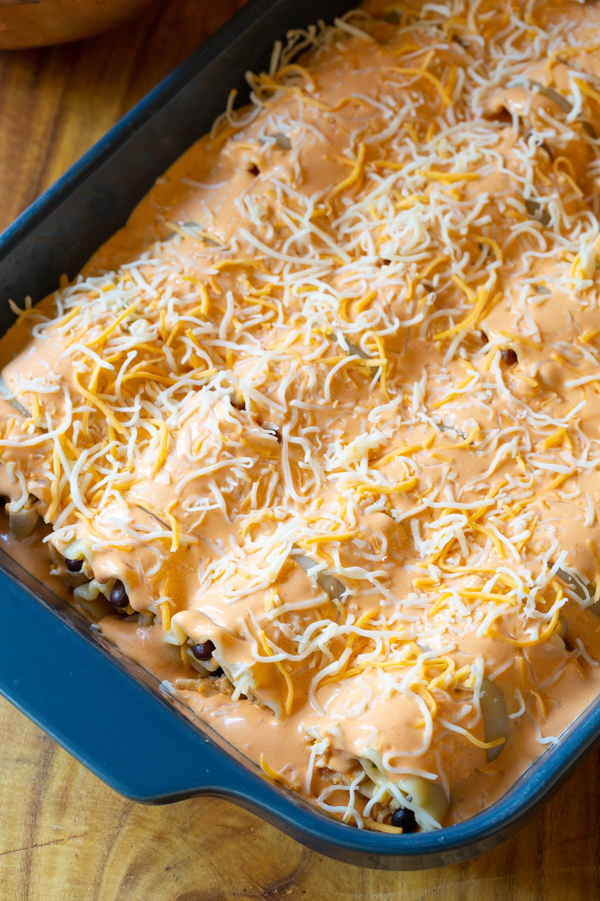 Baking sheet filled with rolled up lasagna ready to bake. 