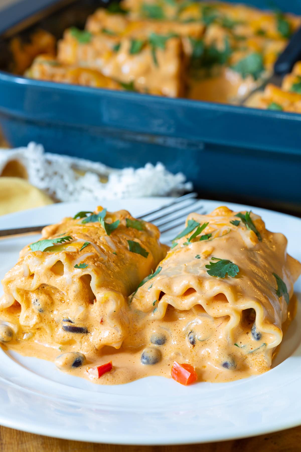 Two lasagna rolls on a plate. 