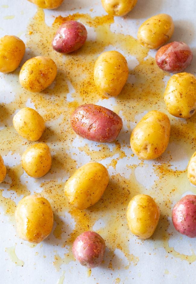 baby potatoes seasoned on baking sheet