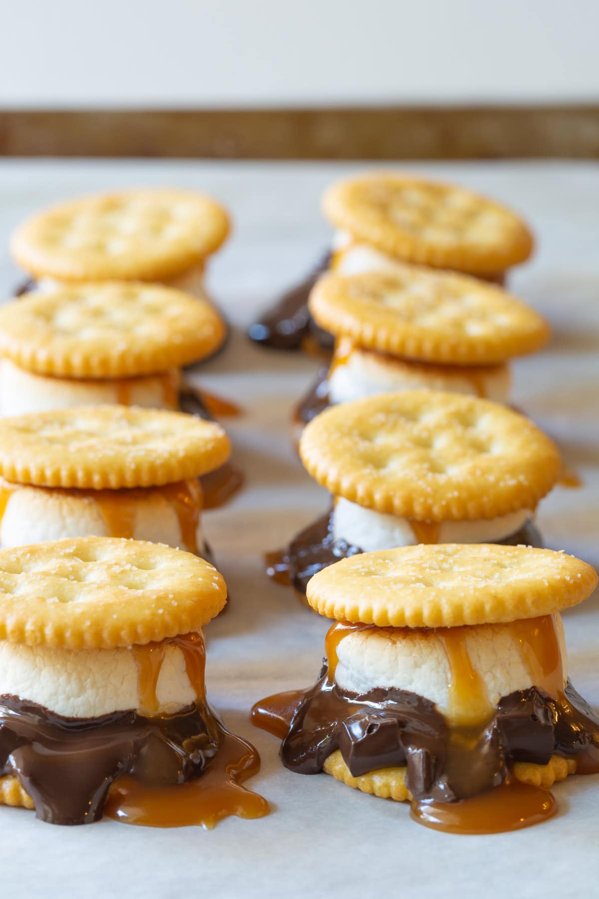 Ritz cracker smores with dark chocolate, marshmallows and salted caramel sauce.