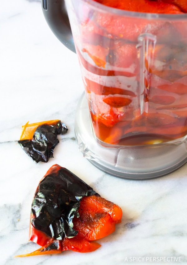 Peeling the roasted red peppers and placing them in a blender. 