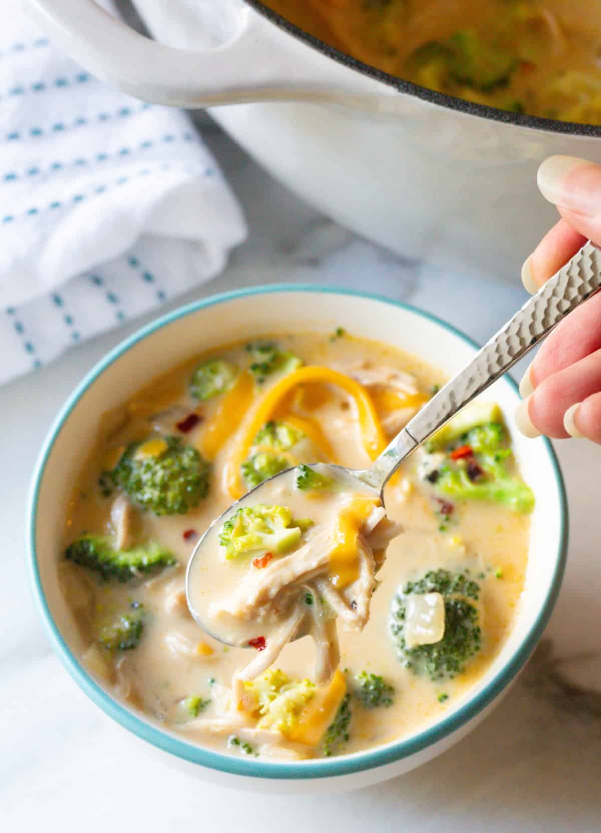 soup with broccoli and cheese in spoon