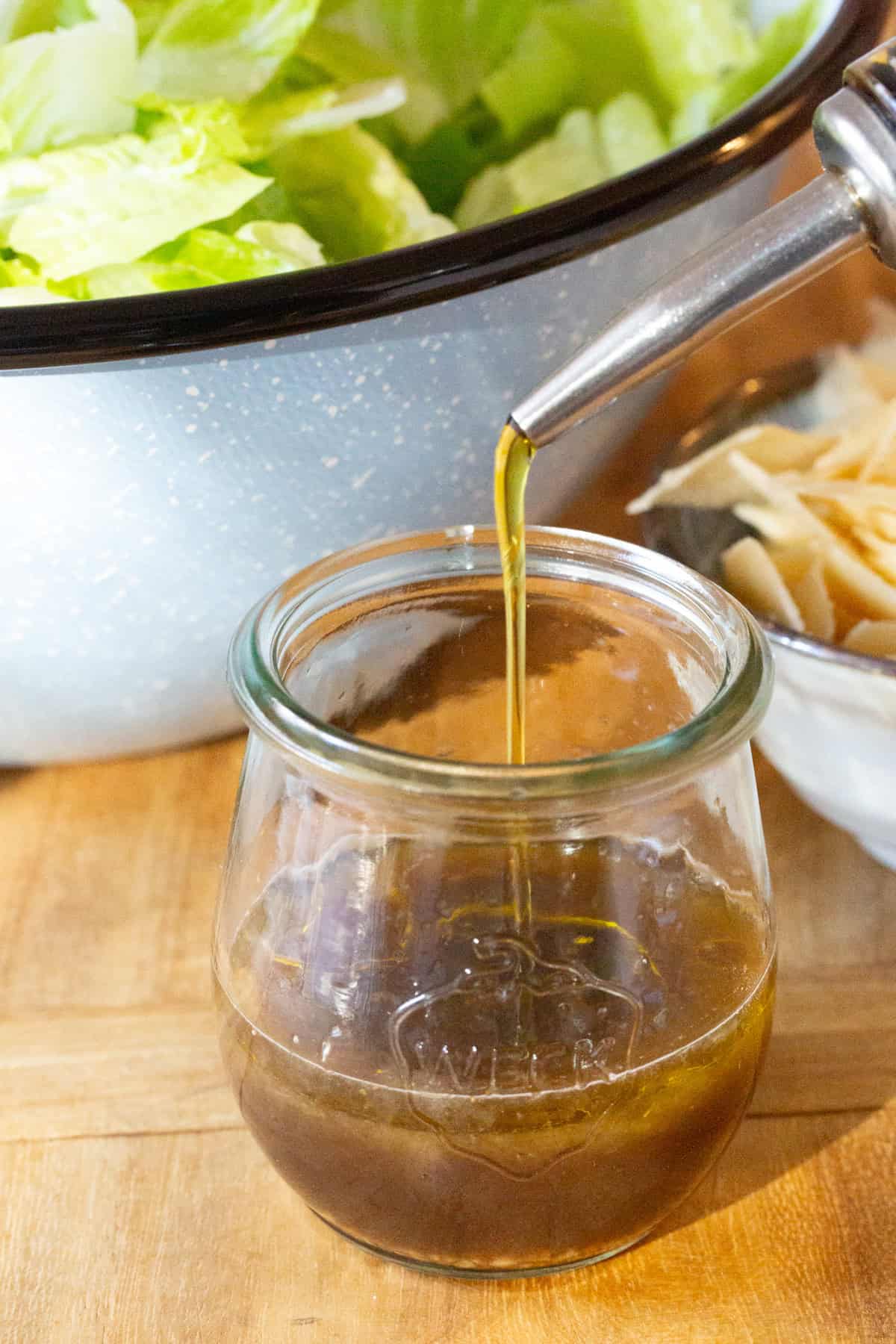 Olive oil being poured into a jar. 