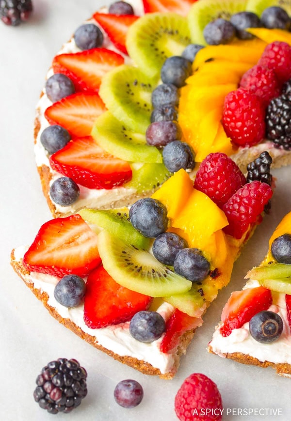 Closeup of slice of vegan fruit pizza being removed from pizza.