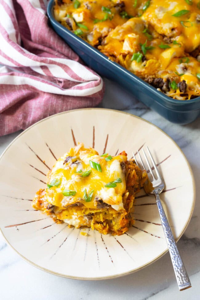 Slice of lasagna on a plate with a fork.