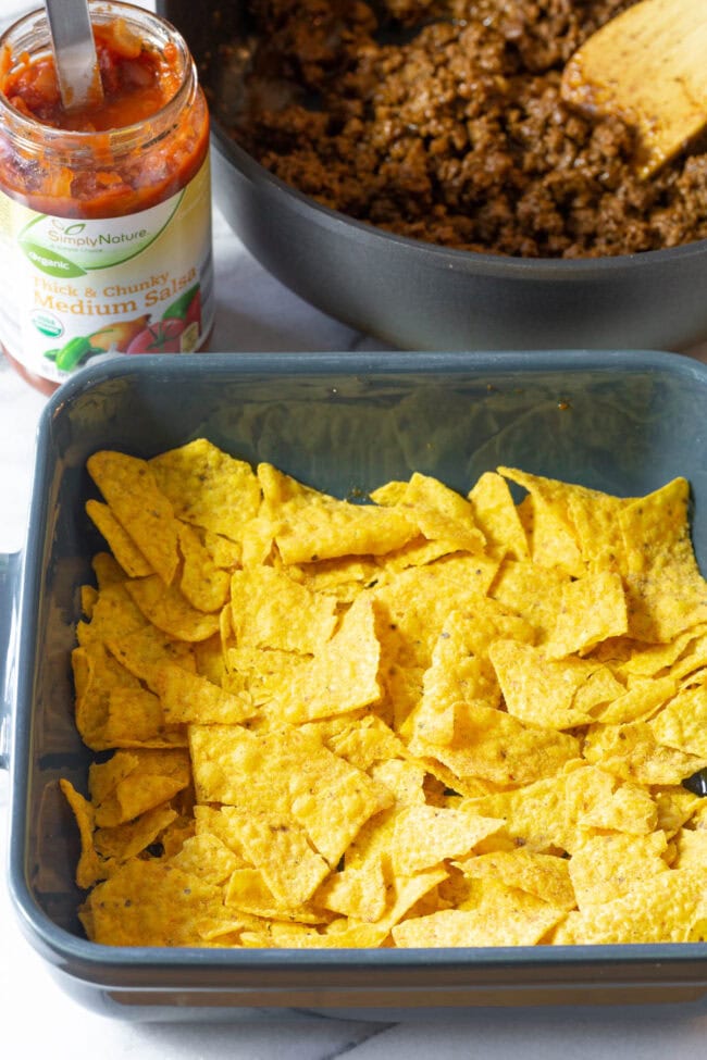 Crushed Doritos in baking tray.