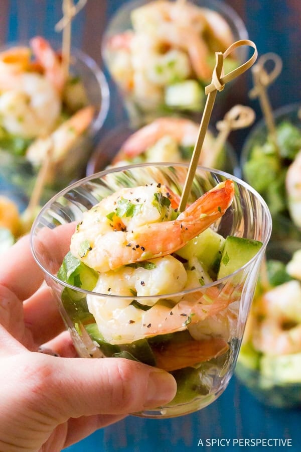Hand holding a cup filled with shrimp salad.