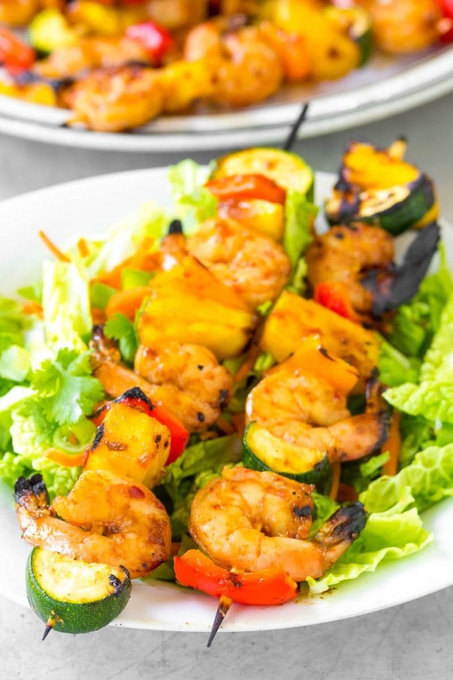 Closeup shot of cooked shrimp skewers on a plate. 
