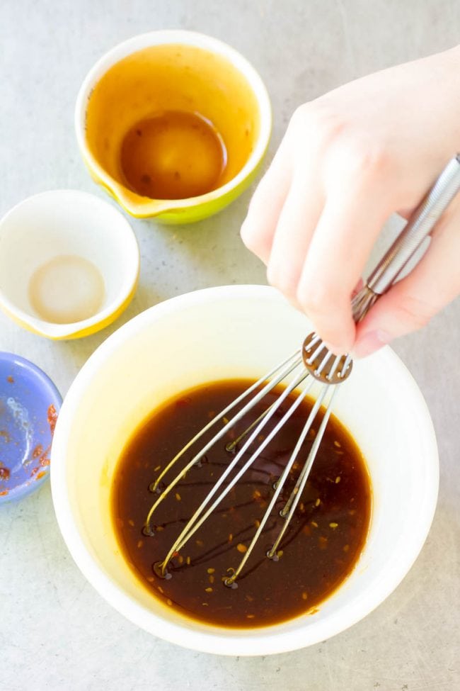 Overhead of hand whisking the ingredients for the marinade. 