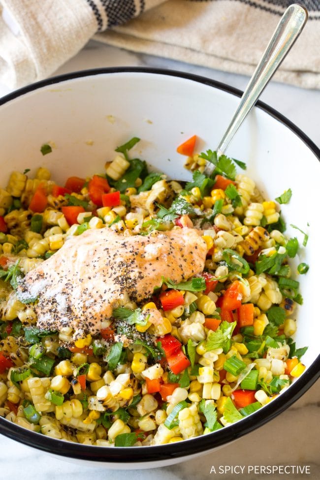 Creamy salad dressing being tossed into salad.