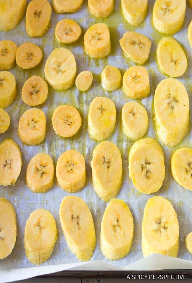 sliced plantains on baking sheet before baking