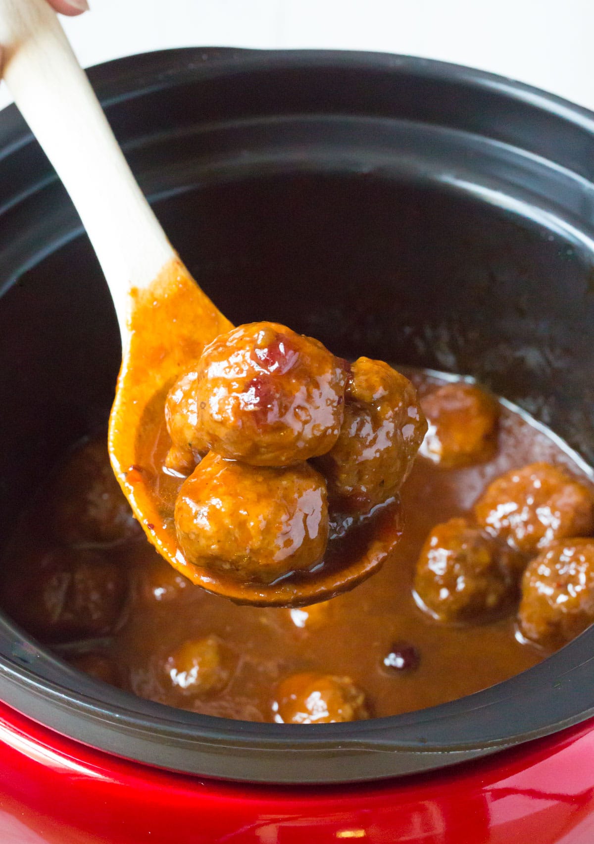 Last and final look at this slow cooker recipe with the meat and sauce on a wooden spoon
