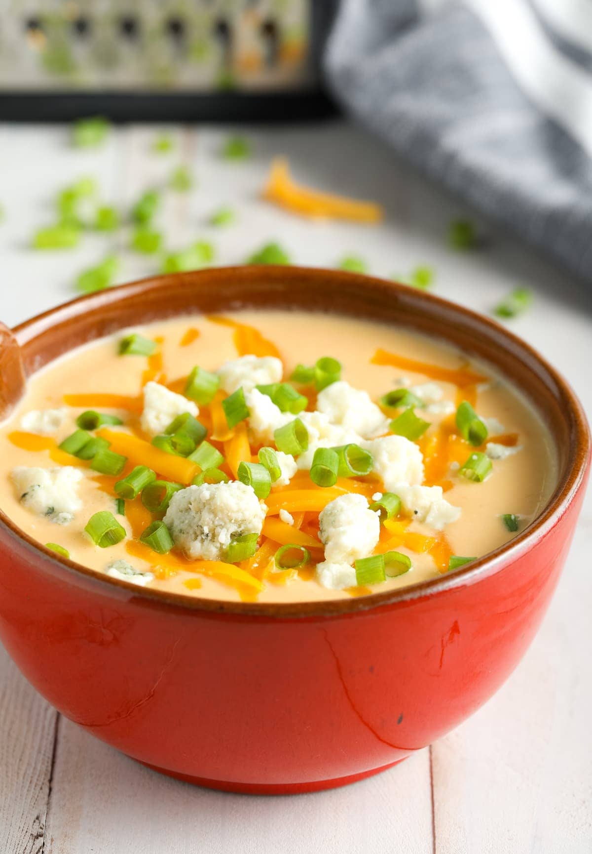 Buffalo Cauliflower Cheese Soup Recipe - creamy soup in a bowl bowl with toppings.