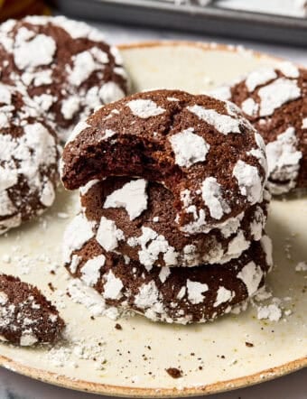 Mexican Mocha Crinkle Cookies Recipe stacked on plate with bite taken out of top cookie