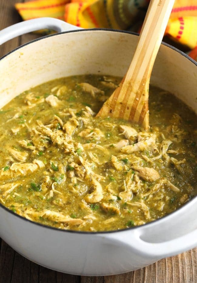 Wooden spoon combining all of the ingredients in the pot. 