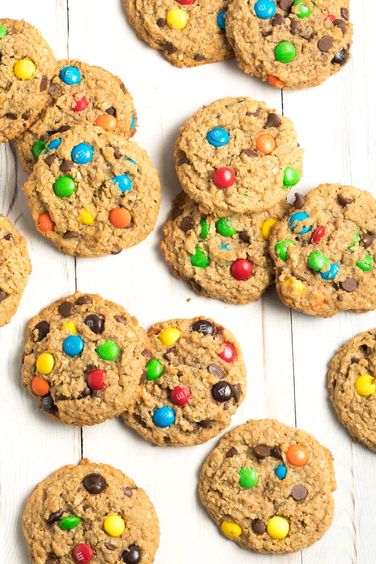 Top down view a dozen peanut butter oatmeal monster cookies with m&m candies.