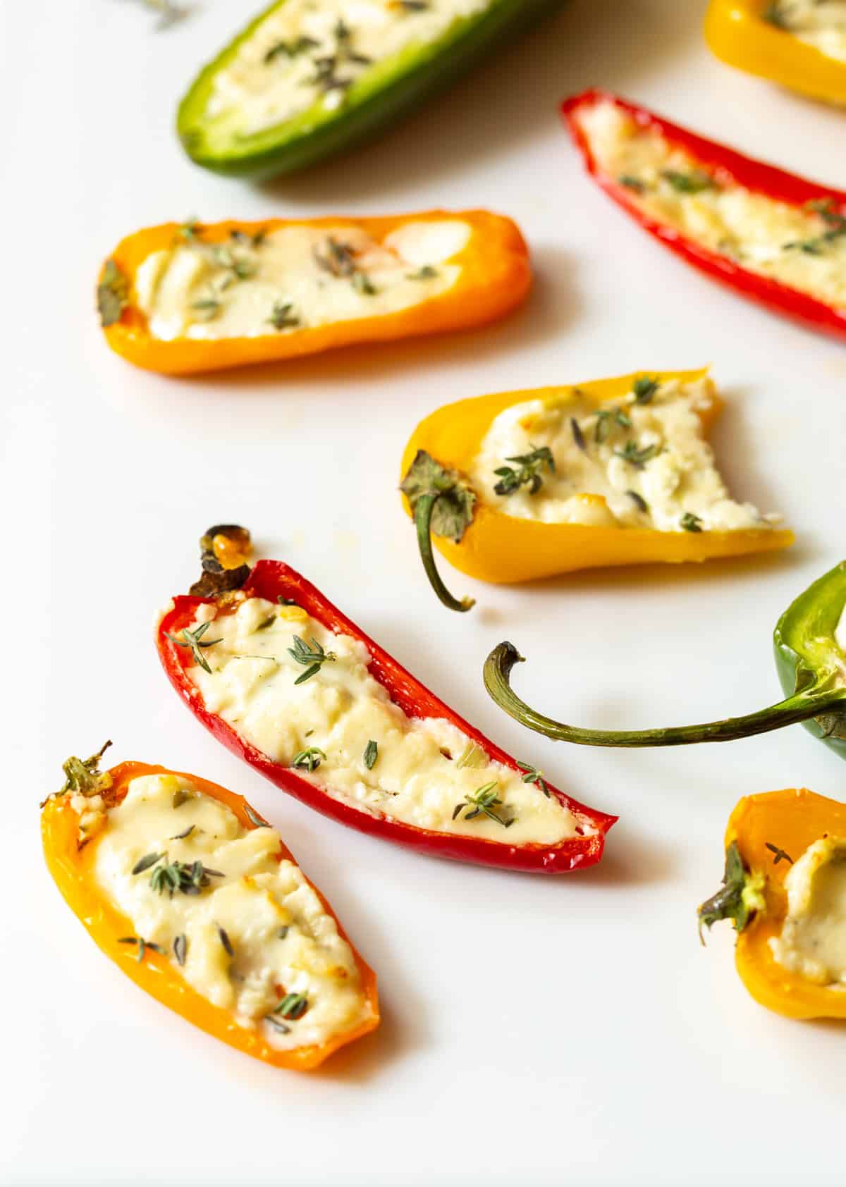 close up shot of mini stuffed peppers with fresh thyme on top