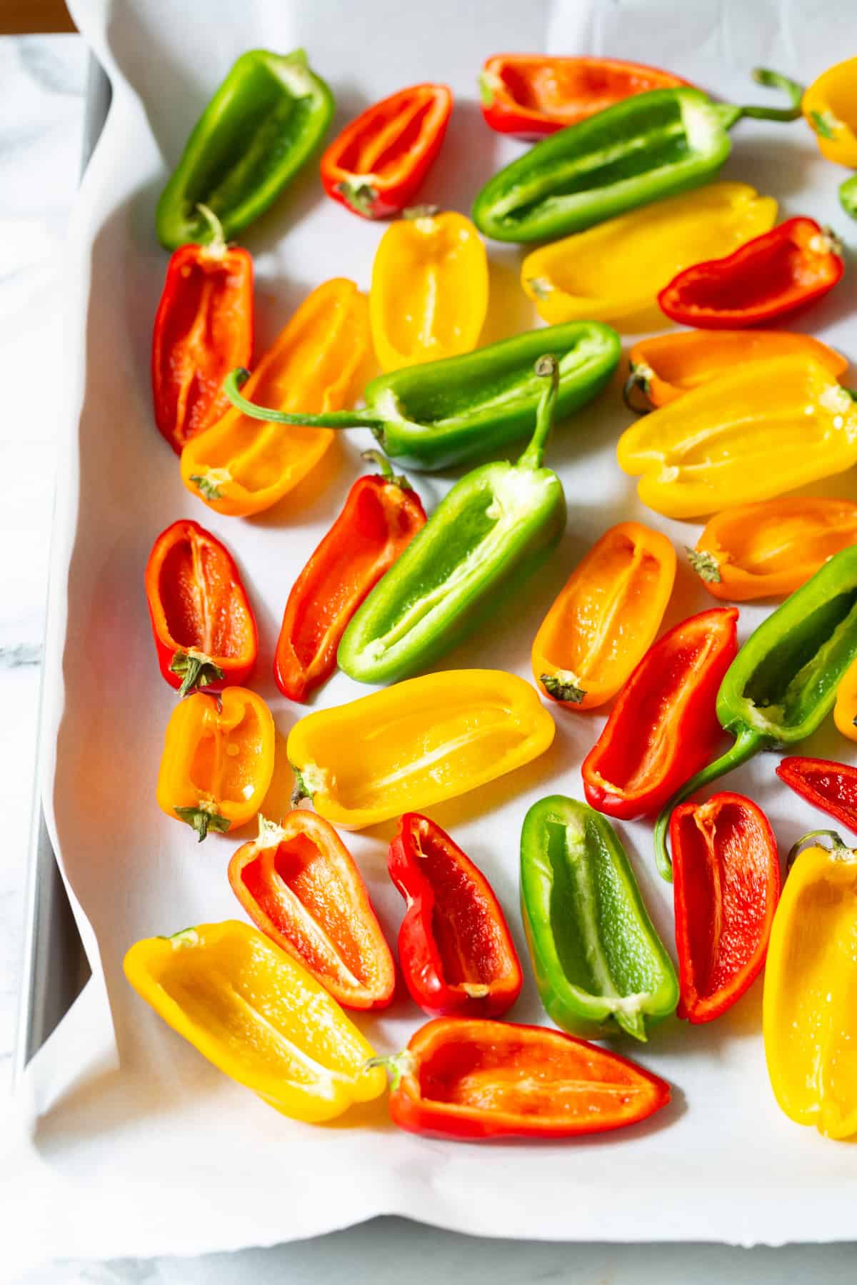 bell peppers cut in half on a baking sheet