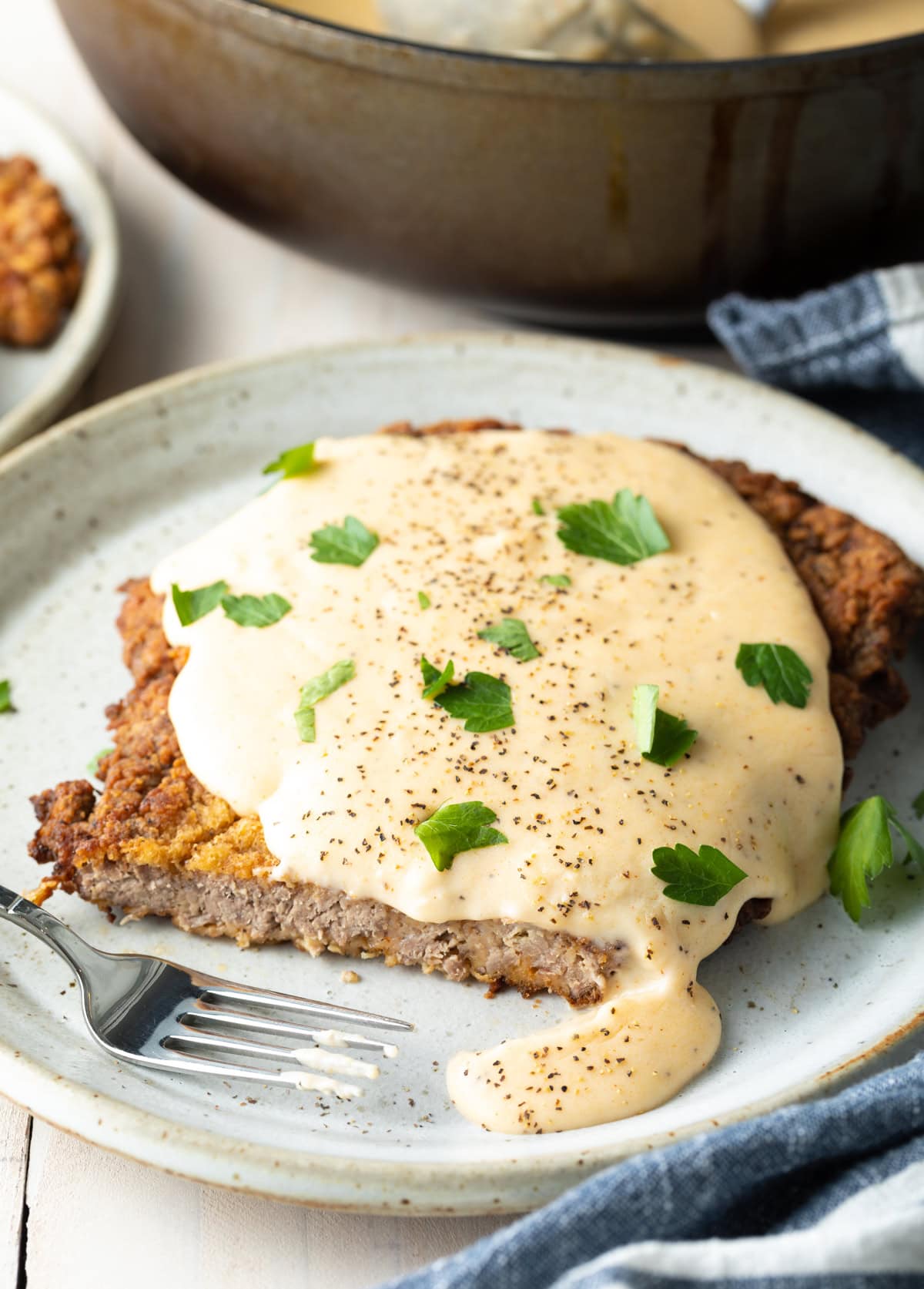 Sliced chicken fried steak on a plate.