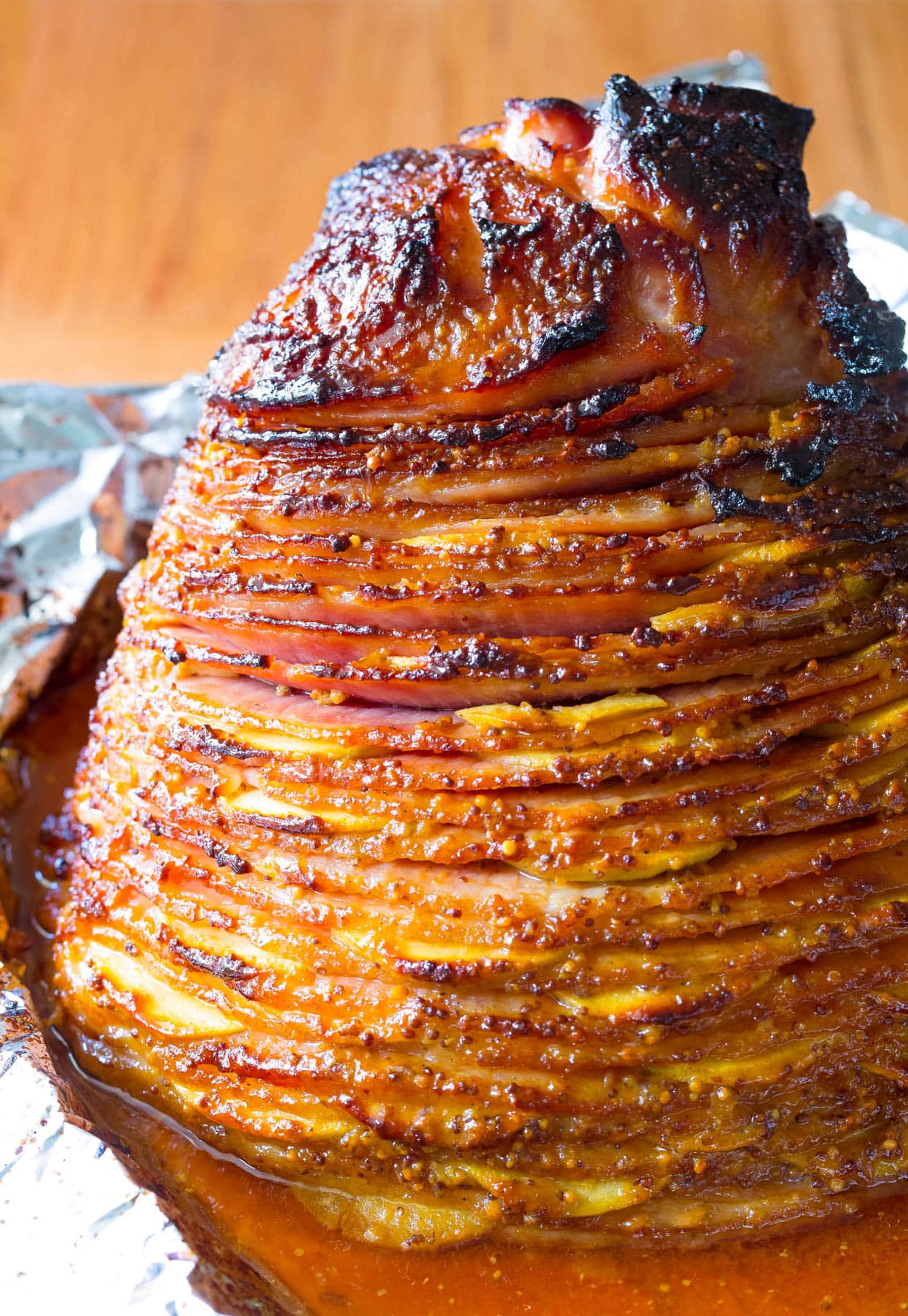 Close up baked ham with apples in a baking tray.