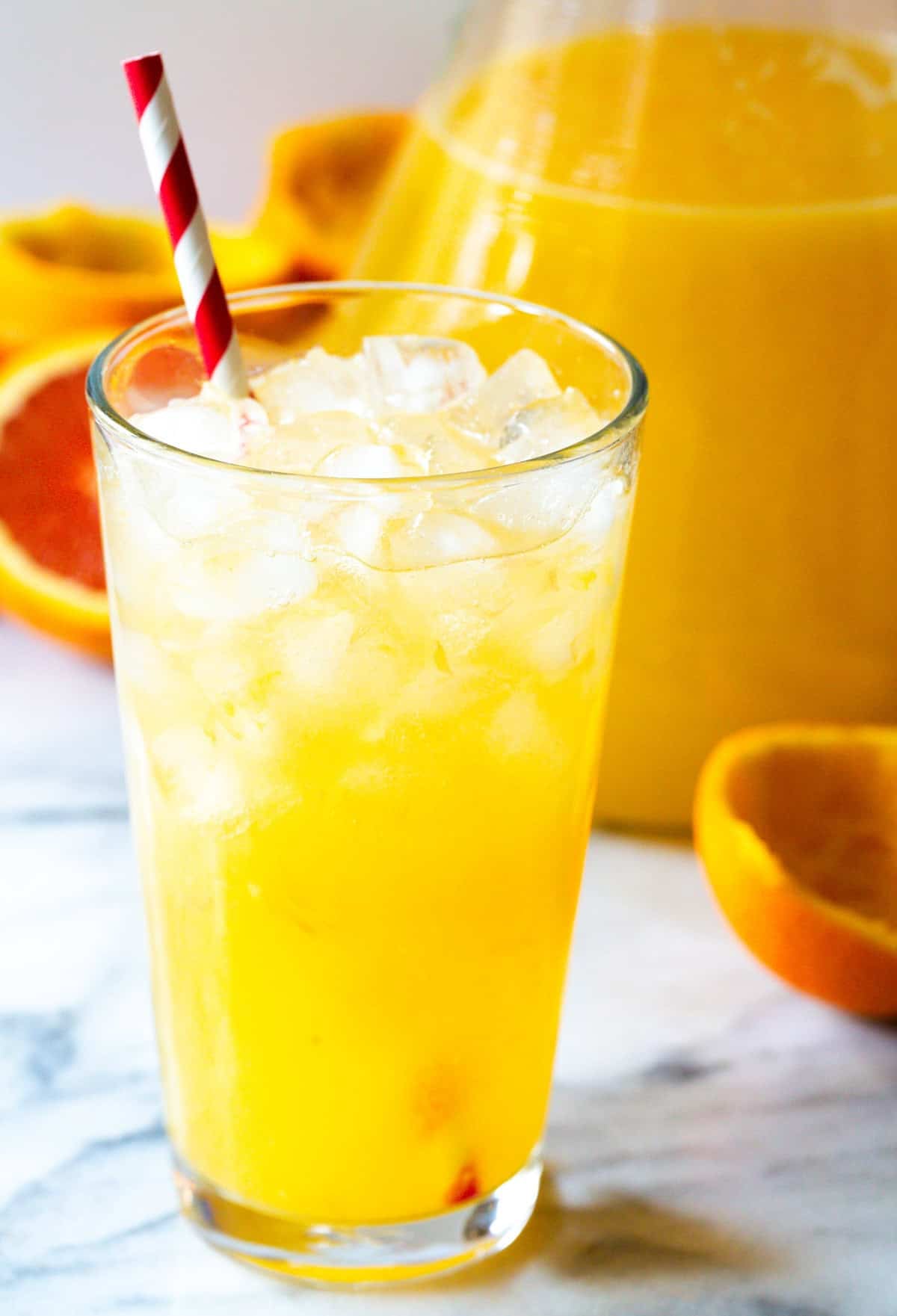 Orangeade in a tall glass with a straw