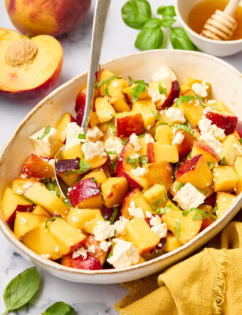 Peach Salad with basil and goat cheese on plates