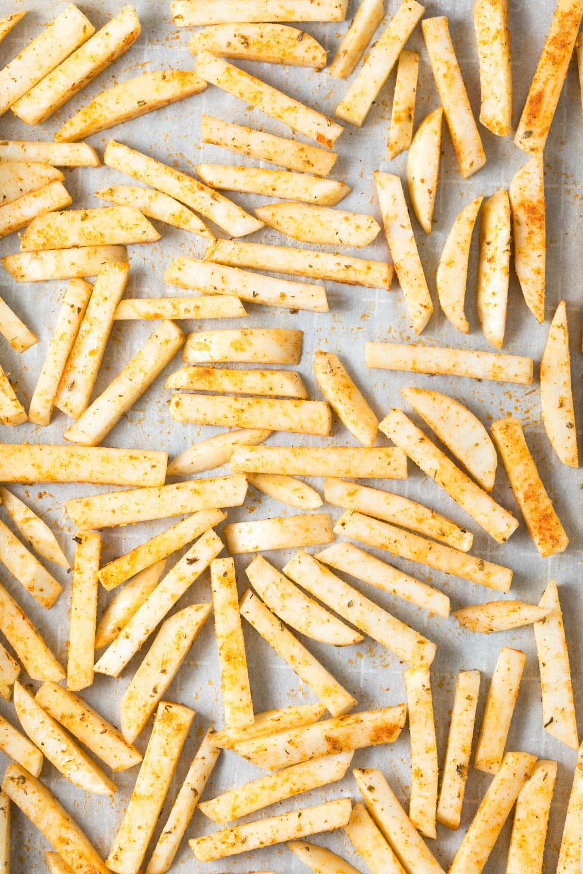Fries coated in spice mix ready to bake. 