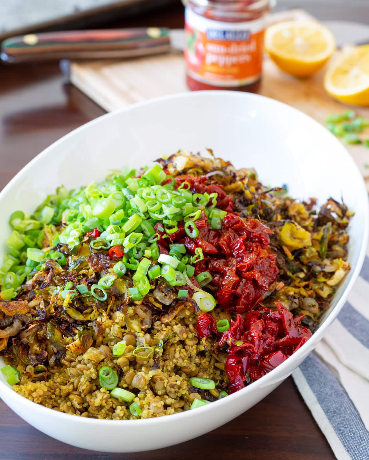 quinoa lentil salad.  Top photo of quinoa, lentils, peppers, onions and brussels sprouts in a white bowl.  