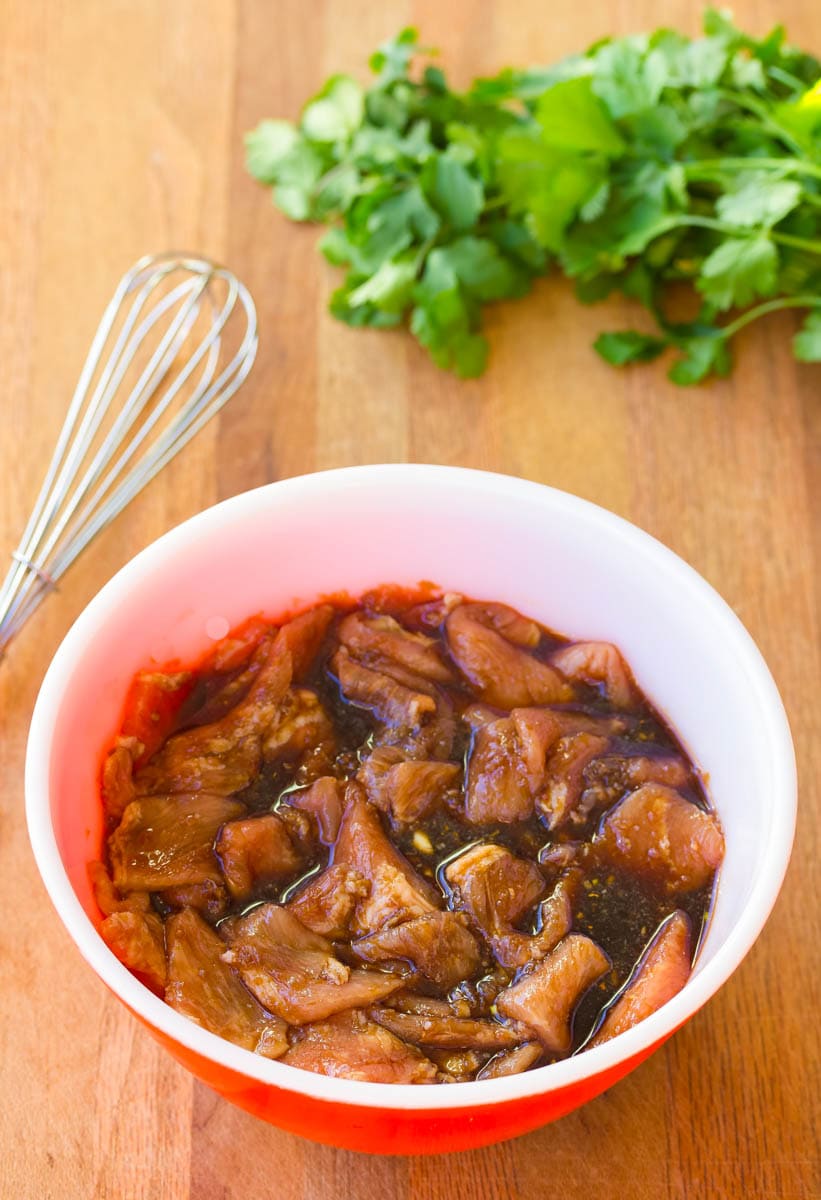 Sliced pork marinating in a bowl.